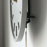 Grijze beton klok aan de wand in de woonkamer